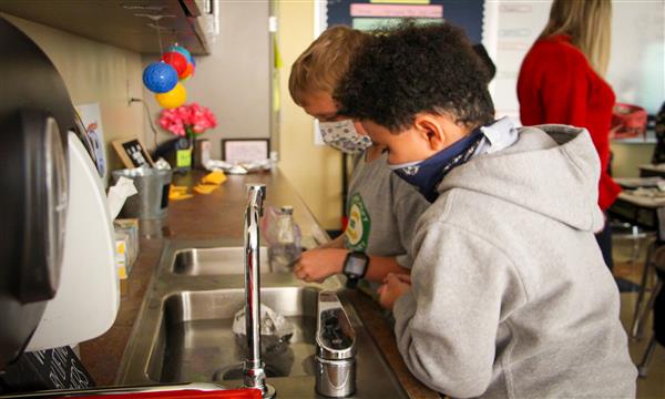 Boys test aluminum boats in sink